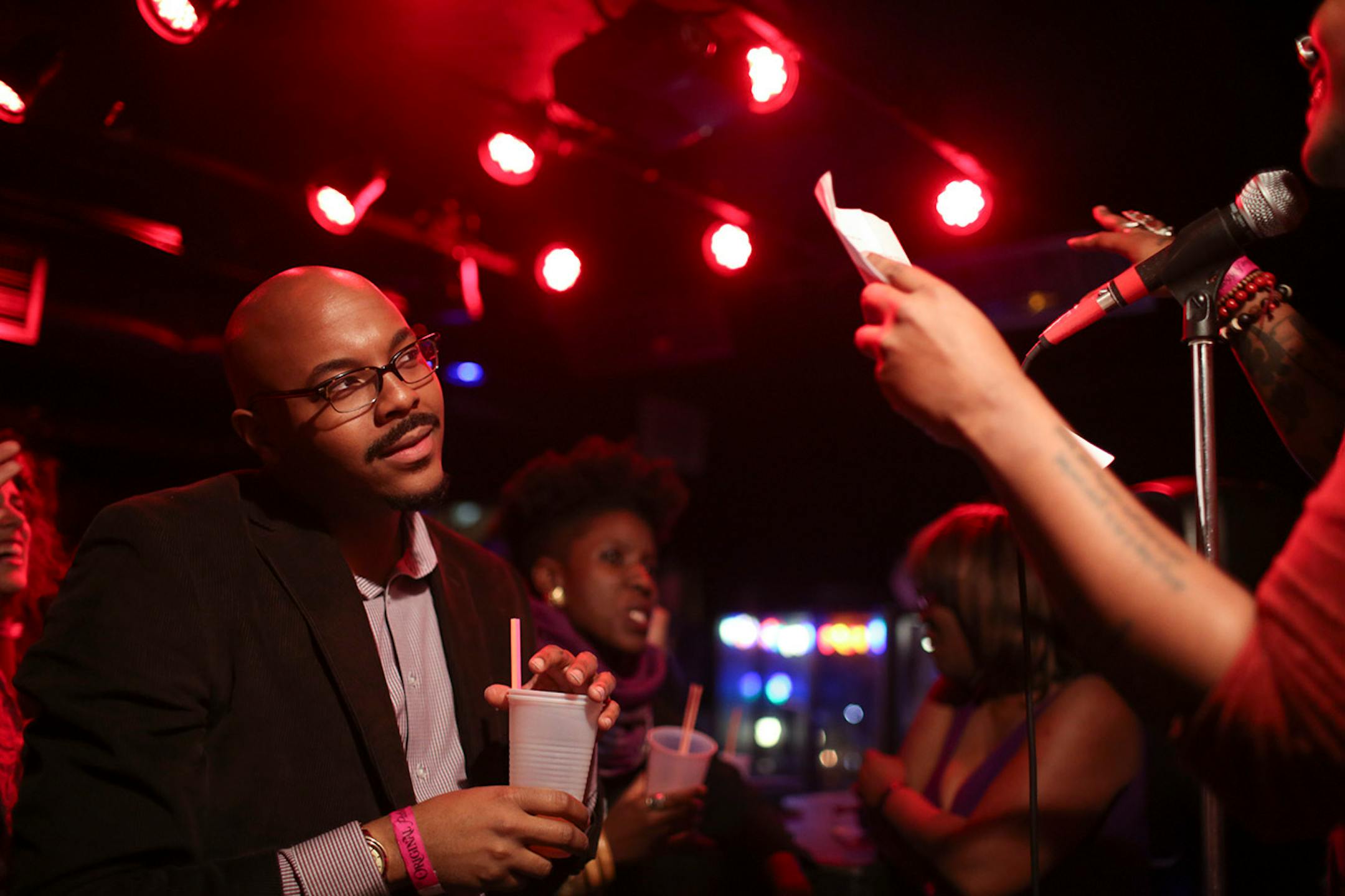 Poet Nate Marshall, left, listened to the reading of a Prince-inspired poem by Danez Smith during The Prince Purple Poetry Party Wednesday night at First Ave. ] JEFF WHEELER • jeff.wheeler@startribune.com One of the off-site events at the start of the AWP Conference & Bookfair was The Prince Purple Poetry Party Wednesday night, April 8, 2015 in The Record Room at First Ave. in Minneapolis. More than a dozen poets read poems they wrote that were inspired by the music of Prince.