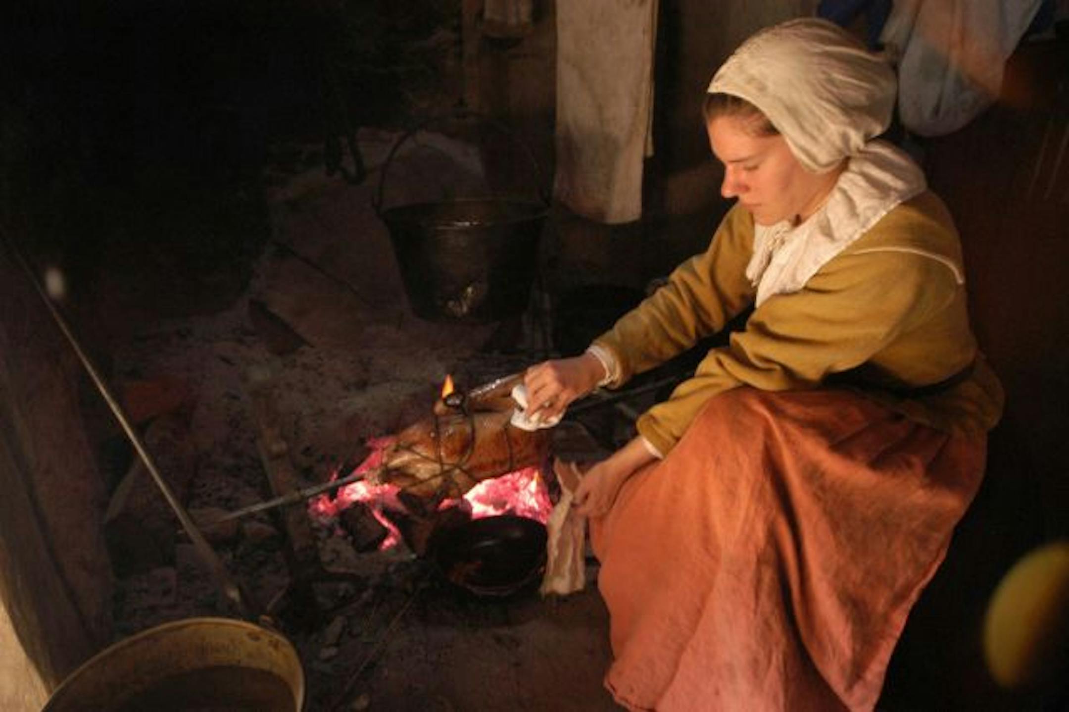 Tara Brook inhabits the role of colonist Barbara Standish, roasting a goose on a spit at Plimoth Plantation, a re-creation of the Massachusetts colony in 1627.
