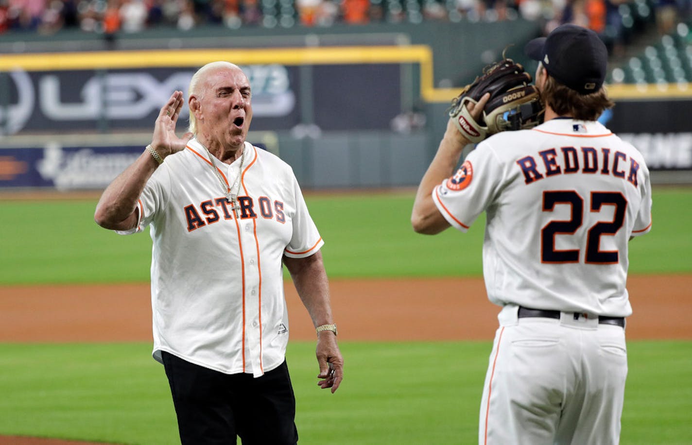 Professional wrestler legend Ric Flair, left, greets Houston Astros right fielder Josh Reddick (22) after throwing out the ceremonial first pitch before a baseball game against the Detroit Tigers on Wednesday.