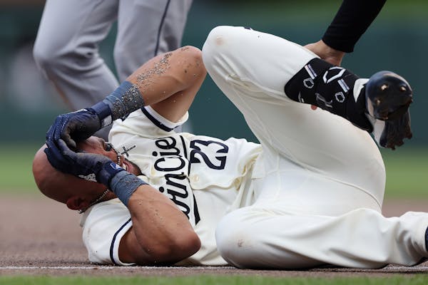 Minnesota Twins' Royce Lewis reacts after colliding with Cleveland Guardians first baseman Gabriel Arias during the eighth inning of a baseball game, 