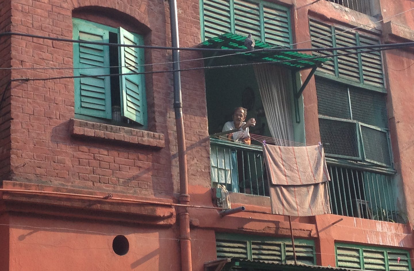 A man takes in the morning from his balcony in Kolkata, India. Photo by Diane Richard * Special to the Star Tribune