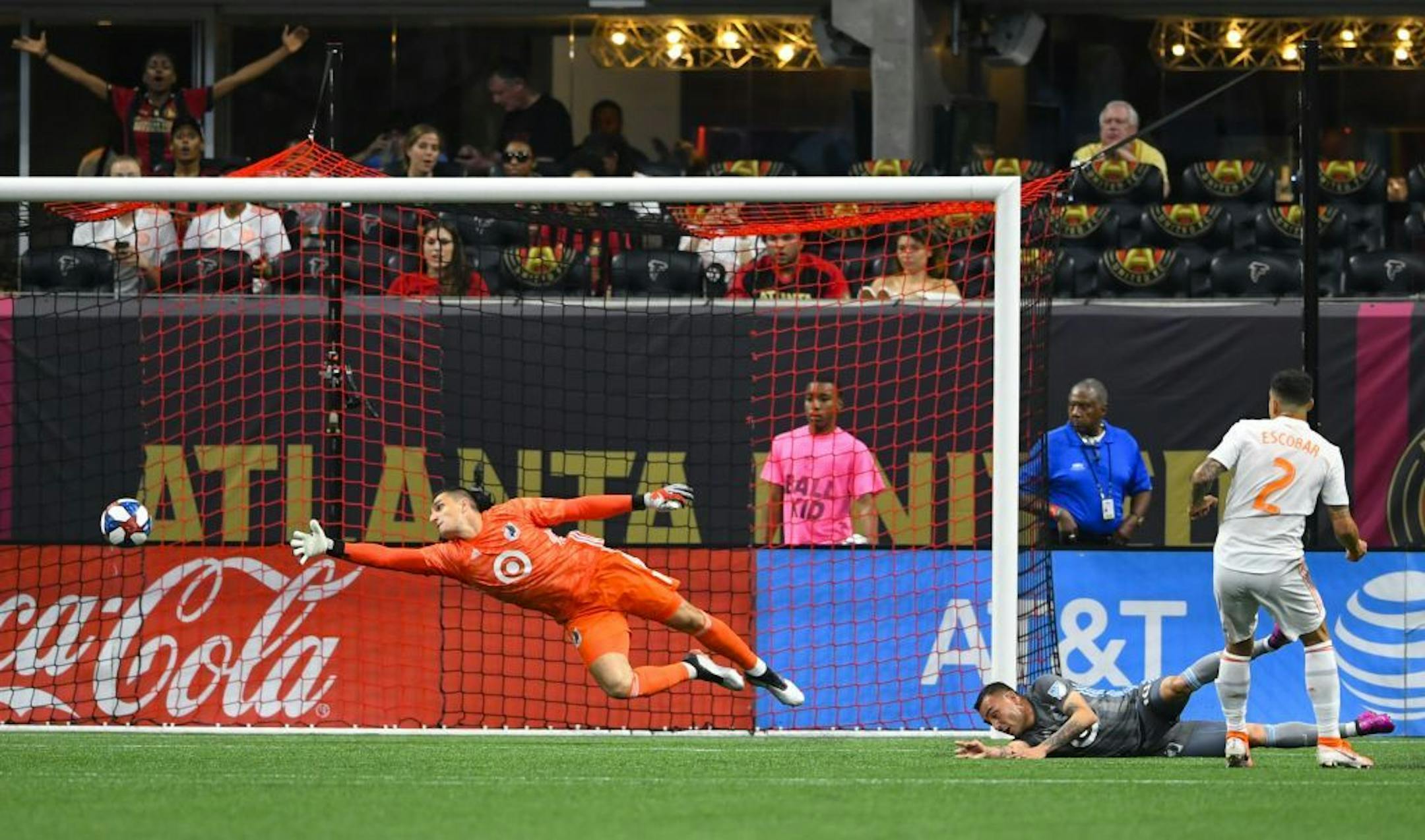 Minnesota United goalkeeper Vito Mannone dives as Atlanta United defender Franco Escobar (2) gets a shot past him to score during the first half of an MLS soccer match Wednesday, May 29, 2019, in Atlanta.