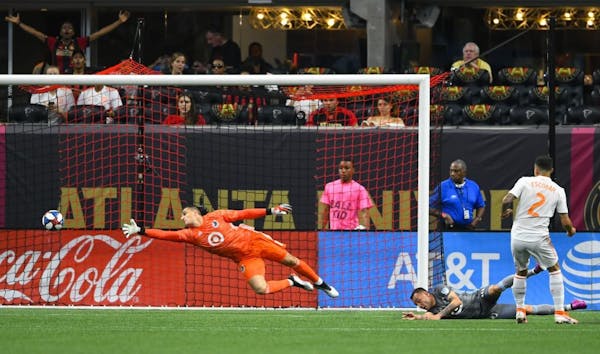 Minnesota United goalkeeper Vito Mannone dives as Atlanta United defender Franco Escobar (2) gets a shot past him to score during the first half of an