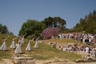 Visitors watch the performers, who will take part in the flame lighting ceremony for the Paris Olympics, during a rehearsal at Ancient Olympia site, G