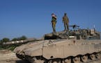 Israeli soldiers stand on their tank in a staging area near the Israel-Gaza border in southern Israel, Wednesday, Feb. 28, 2024. (AP Photo/Tsafrir Aba