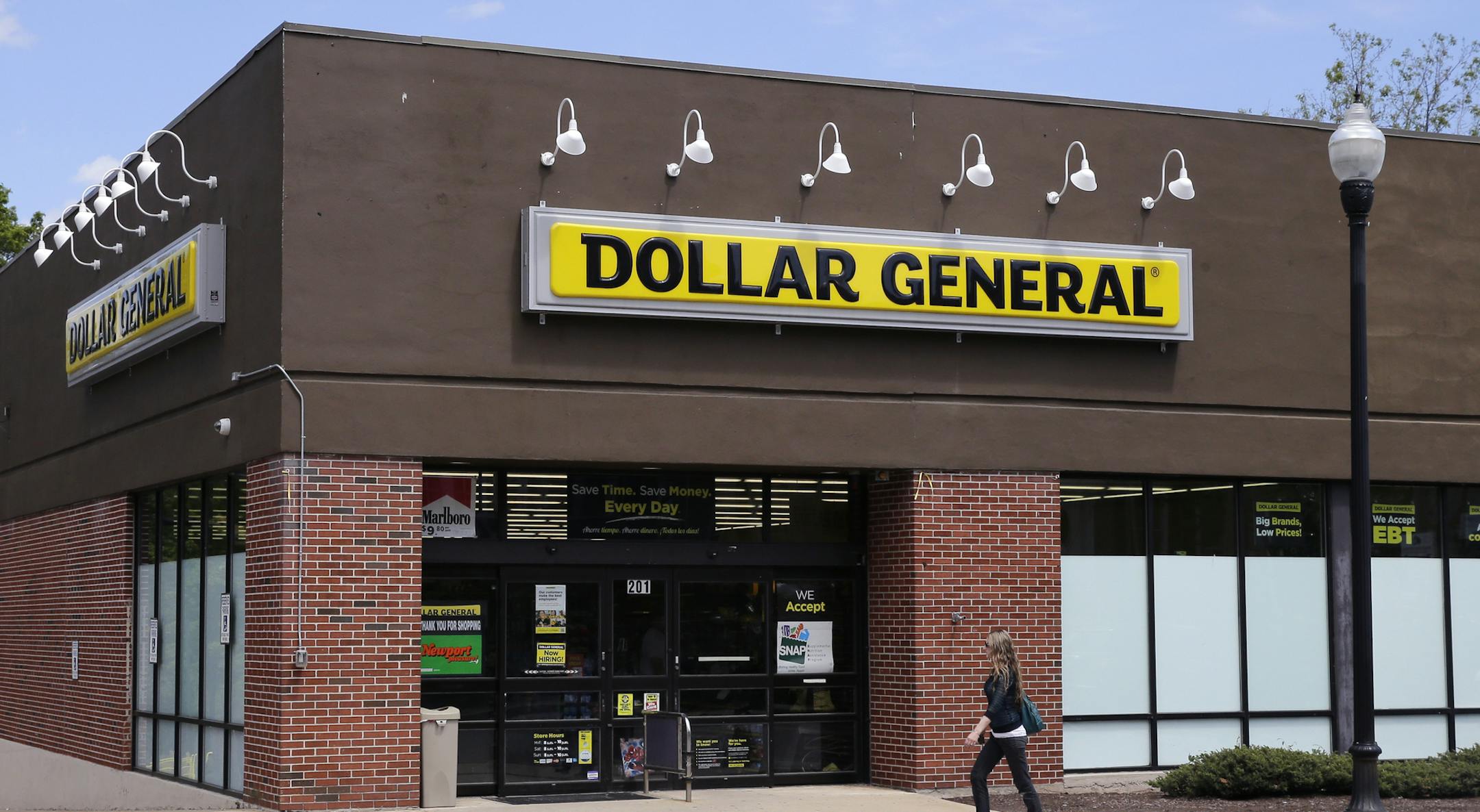 FILE - In this Wednesday, May 18, 2016, file photo, a woman walks past a Dollar General store in Methuen, Mass. On Thursday, Aug. 25, 2016, Dollar General reports financial results. (AP Photo/Charles Krupa, File)