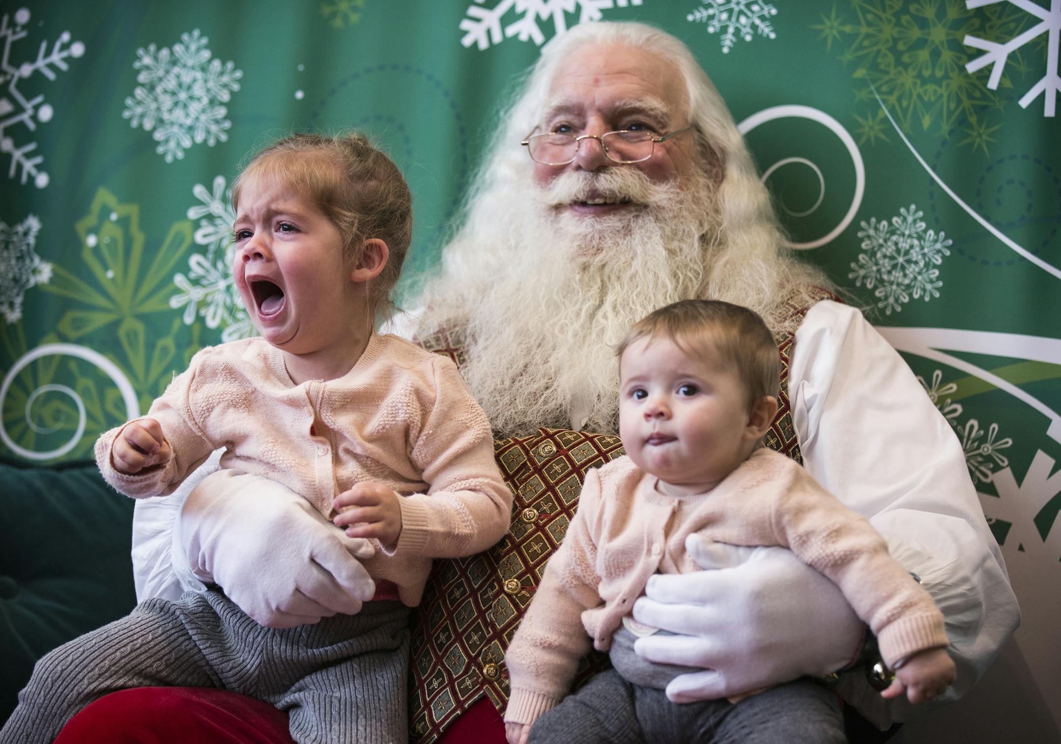 Viviana Rivadeneyra, 2, and her seven-month-old sister Emma Ines Rivadeneyra, both of Bloomington, pose for a photo with Santa (who would not give his real name) at Southdale Center in Edina on Thursday, December 24, 2015. ] (Leila Navidi/Star Tribune) leila.navidi@startribune.com