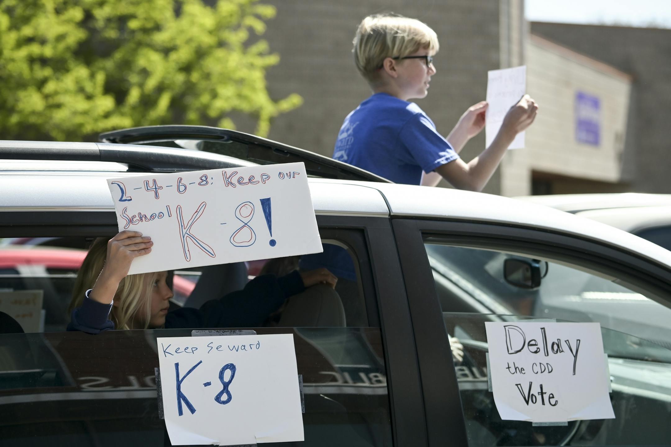 Young protesters demonstrated from a moving vehicle during an anti-CDD drive-by protest in front of the Minneapolis Public School headquarters in north Minneapolis Friday.