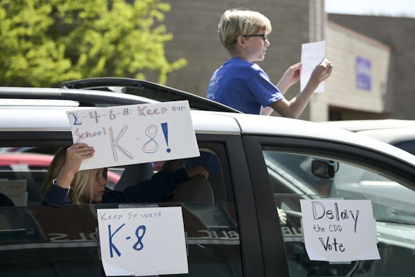 Young protesters demonstrated from a moving vehicle during an anti-CDD drive-by protest in front of the Minneapolis Public School headquarters in nort