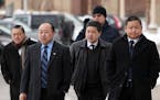 St. Paul City Council Member Dai Thao, right, walked with a group of men into the Ramsey County Law Enforcement Center for his hearing Tuesday. ] ANTH