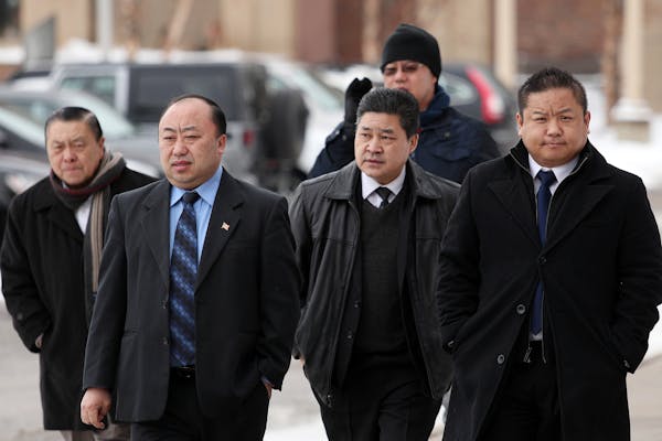 St. Paul City Council Member Dai Thao, right, walked with a group of men into the Ramsey County Law Enforcement Center for his hearing Tuesday. ] ANTH