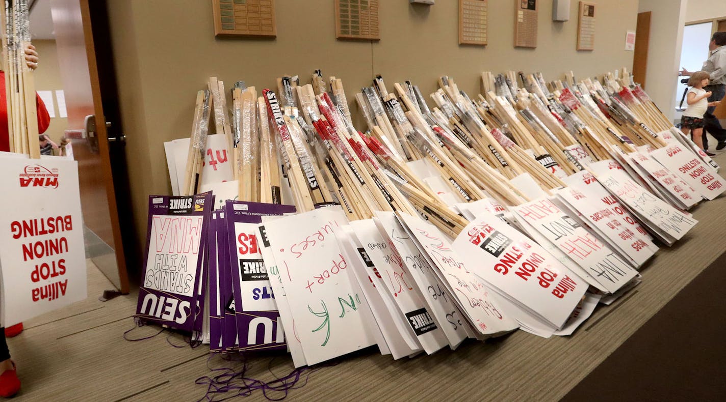 Valerie Johnson, an RN at Abbott Northwestern Hospital, added to the pile as MNA nurses, Minnesota Nurses Association employees and family members joined forces at the MNA headquarters to make posters for picketing Saturday, June 18, 2016, should a strike happen Sunday at five Twin Cities Allina Health facilities. Cooper' mother Shannon Cunningham is a MNA employee.](DAVID JOLES/STARTRIBUNE)djoles@startribune For the second time in six years, the Twin Cities is on the brink of a major national n