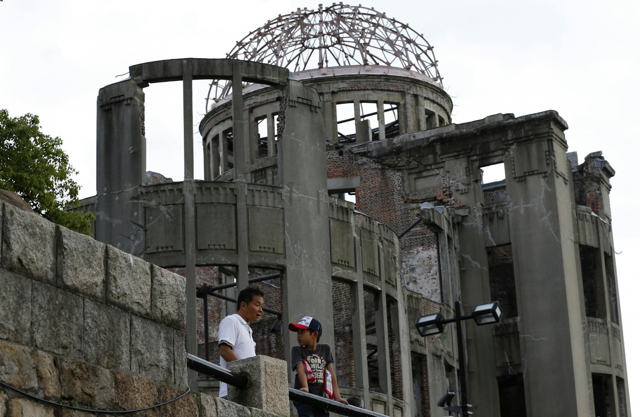 A man and a child stand in front of the Atomic Bomb Dome in Hiroshima, western Japan, Sunday, Aug. 4, 2013.