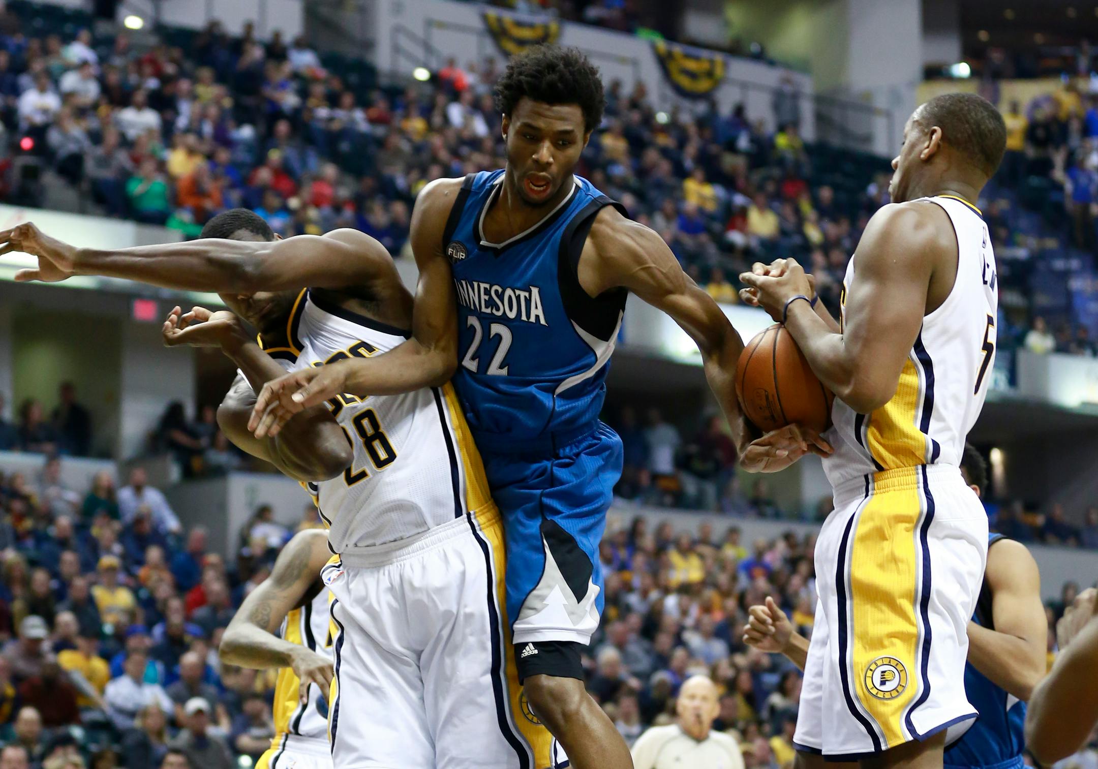 Minnesota Timberwolves guard Andrew Wiggins (22) loses control of the ball defended by Indiana Pacers center Ian Mahinmi, left, and Pacers center Lavoy Allen in the first half of an NBA basketball game, Friday, Nov. 13, 2015, in Indianapolis.
