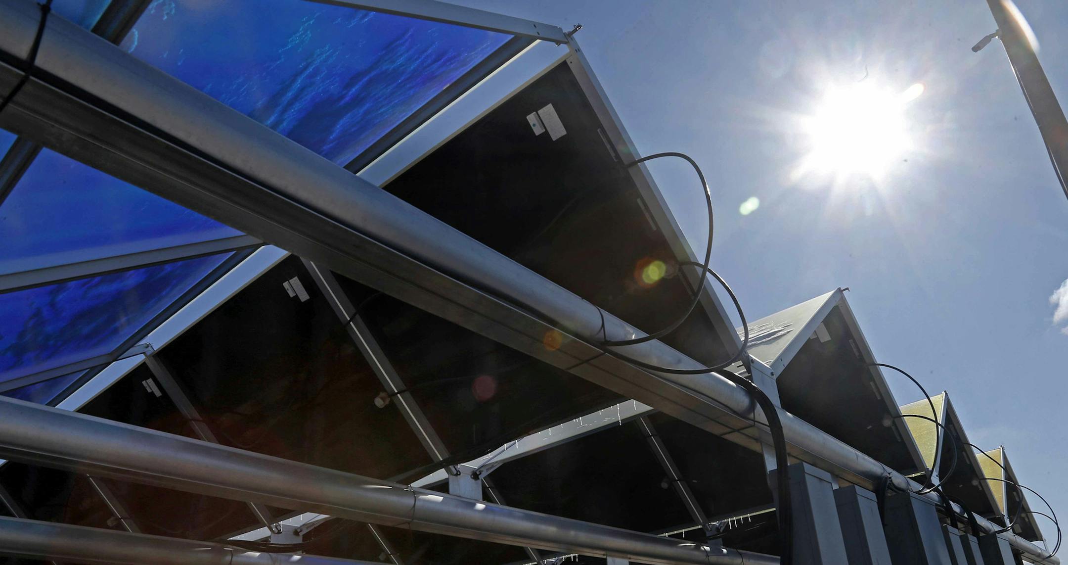 In this Feb. 26, 2015 photo, the sun shines down on solar panels that are part of the Wright-Hennepin Cooperative Electric Association's community gardens are shown in Rockford, Minn. Community solar gardens are a new concept in renewable energy, allowing customers who cannot put up solar panels to buy into the green energy boom anyway. (AP Photo/Jim Mone) ORG XMIT: MP102 ORG XMIT: MIN1503262145334581