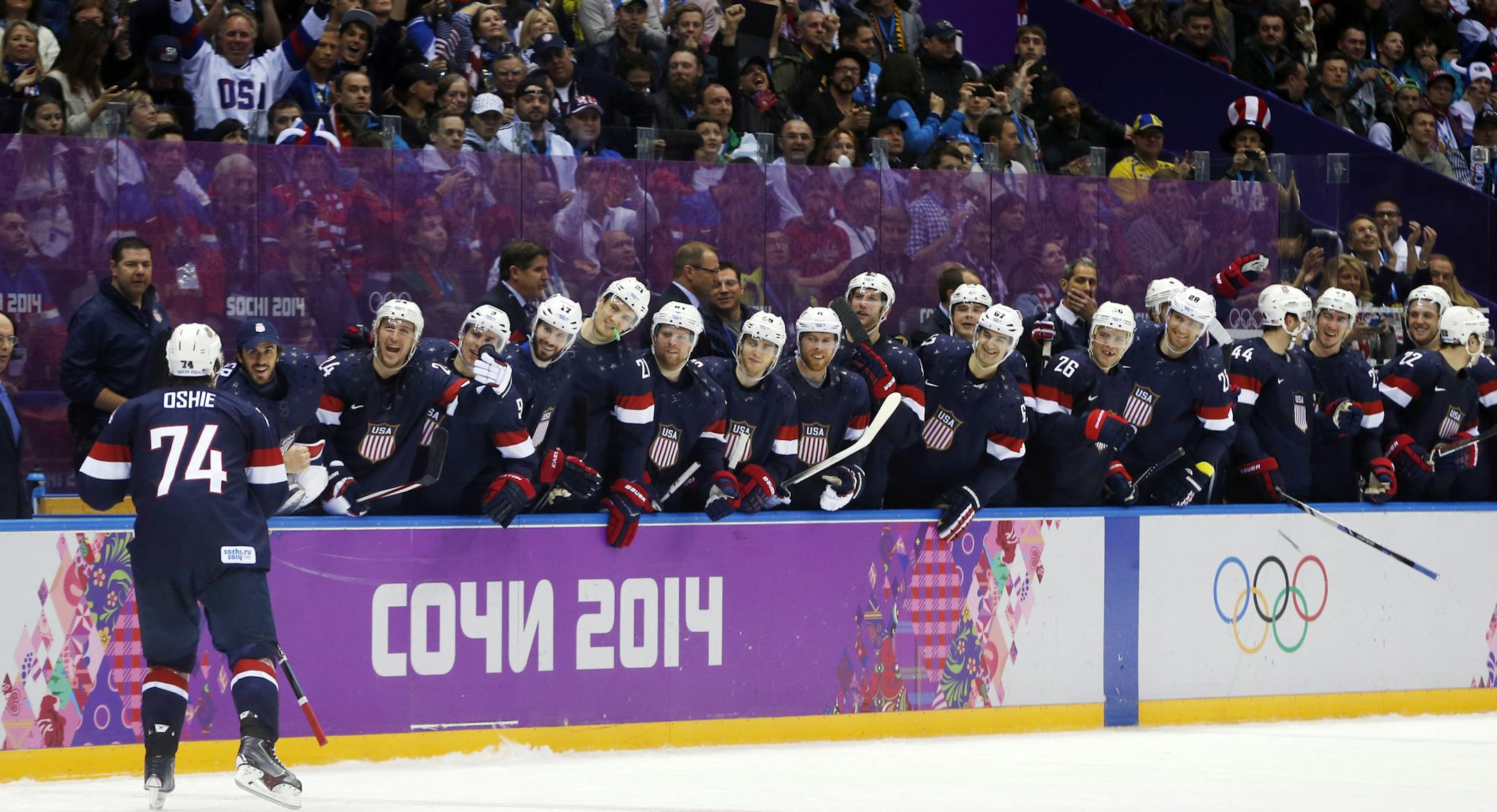 USA forward T.J. Oshie is greeted by teammates after scoring a goal against Russia during a shootout of a men's ice hockey game at the 2014 Winter Olympics, Saturday, Feb. 15, 2014, in Sochi, Russia. (AP Photo/Julio Cortez)