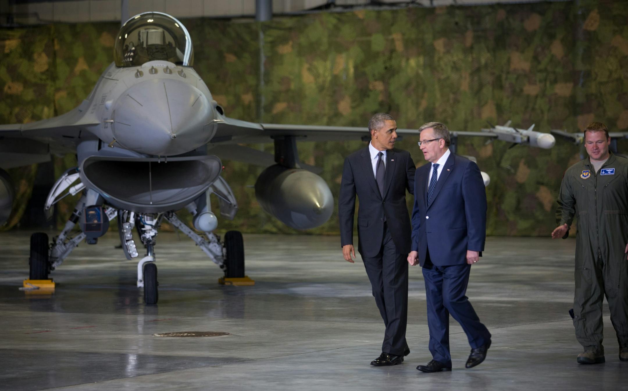 President Obama, left, and President Bronislaw Komorowski of Poland meet with American and Polish airmen in a hangar at Warsaw Chopin Airport, Poland, June 3, 2014. Obama announced more steps on Tuesday to bolster security in central and eastern Europe for the start of a four-day European trip aimed at locking arms with allies following Russia's intervention in Ukraine.