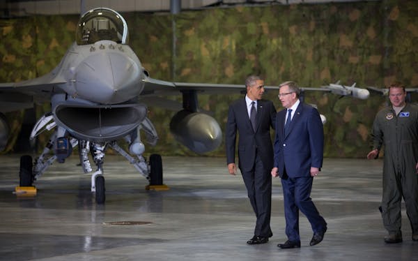 President Obama, left, and President Bronislaw Komorowski of Poland meet with American and Polish airmen in a hangar at Warsaw Chopin Airport, Poland,