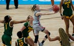 UConn guard Paige Bueckers , center, drives to the basket against Baylor during the first half of a college basketball game in the Elite Eight round o