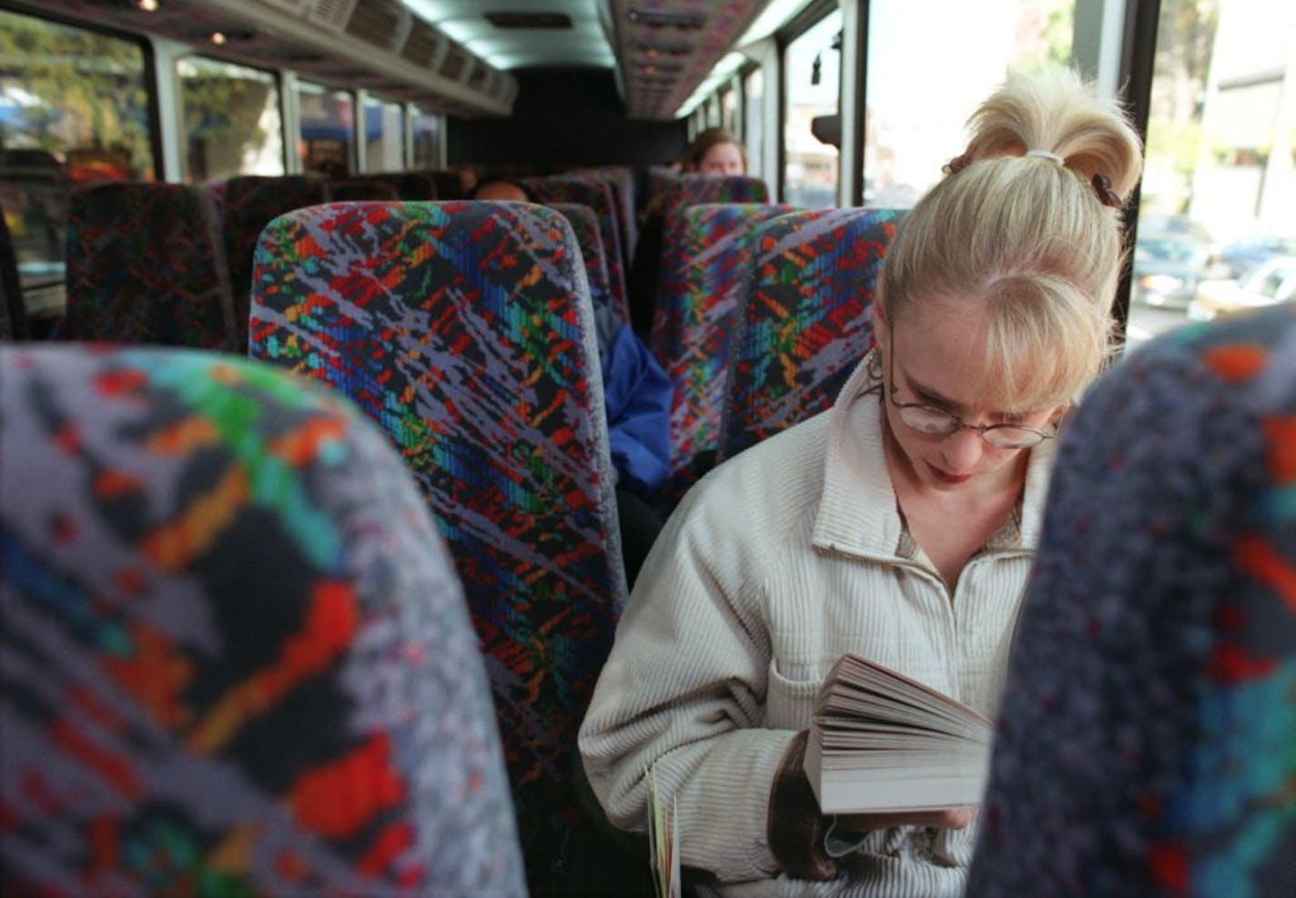 A Metro Transit passenger enjoys her book en route to work. Metro Transit is working to fix a problem with GPS-controlled location announcements.