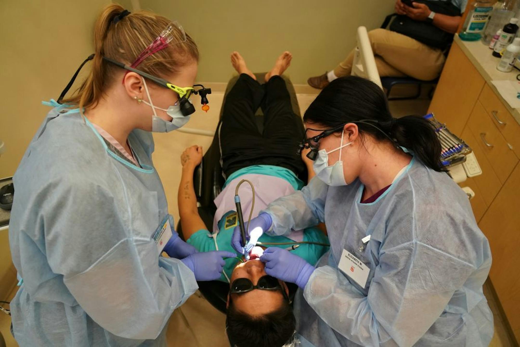 Second year dental students Elizabeth Wilder (right) and Katherine Rolek gave Mow Ning of St. Paul dental care inside Community Dental Care in Maplewood. The two students were part of a group of 35 who continued their education and training through Century College after the abrupt closing of Argosy Univeristy.