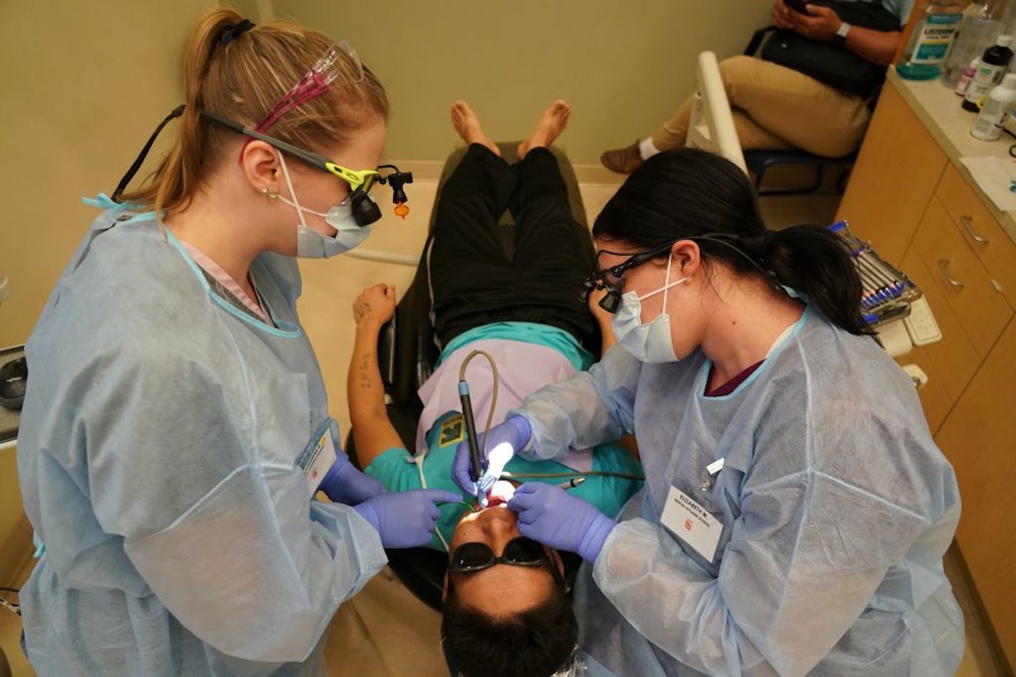 Second year dental students Elizabeth Wilder (right) and Katherine Rolek gave Mow Ning of St. Paul dental care inside Community Dental Care in Maplewood. The two students were part of a group of 35 who continued their education and training through Century College after the abrupt closing of Argosy Univeristy.