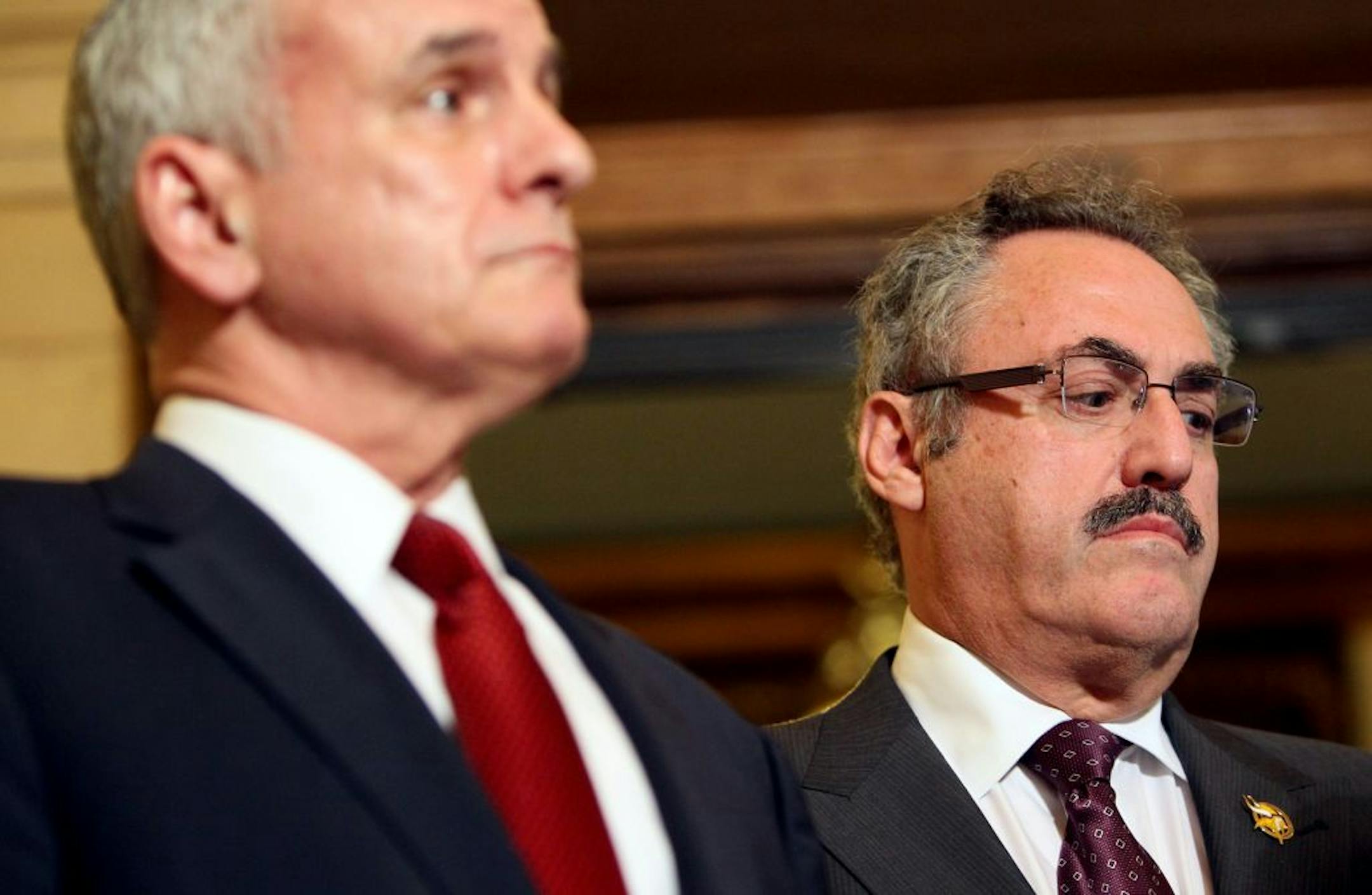 Owner Zygi Wilf (right) and the Vikings won't push for a new stadium bill while Gov. Mark Dayton (left) and the Legislature are trying to resolve their budget impasse.