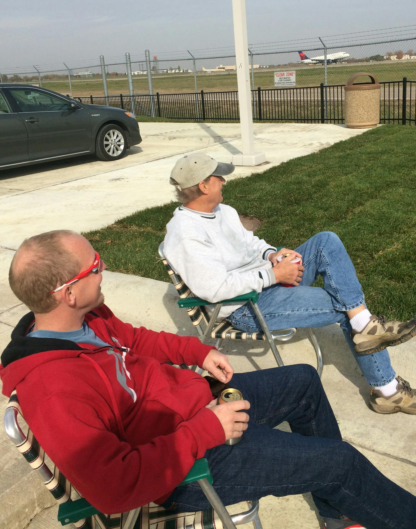 Nate Wintheiser, 38, and his father Gary Wintheiser, 67, were among the first to make themselves at home watching flights take off and land. "If I could have another life, I'd be a pilot," Gary said. credit: Gail Rosenblum, Star Tribune