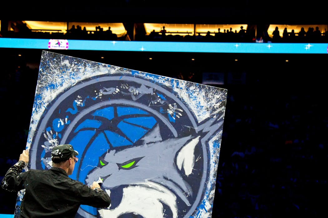 Dan Dunn completes his painting of the new Minnesota Lynx logo during halftime