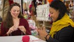 Jennifer Miller, left, a yarn wrangler, and Jessica Owens, manager of Weaving Works in Seattle, Wash. get started on knitting Pussyhats for women to w