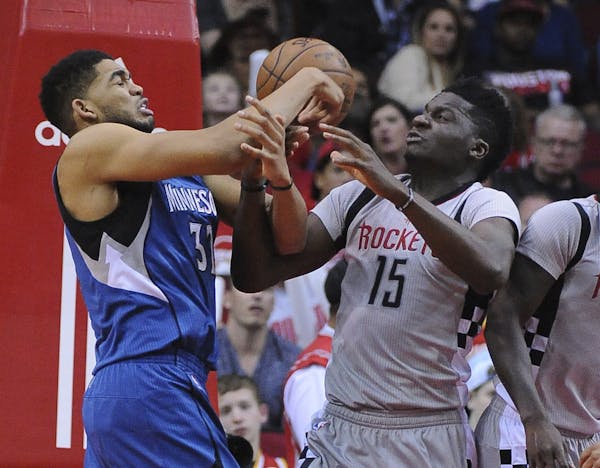 Minnesota Timberwolves center Karl-Anthony Towns (32) and Houston Rockets center Clint Capela (15) struggle for the ball during the second half of an 