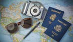 US Passports for travel,camera and glasses on a map of the world. iStockphoto.com