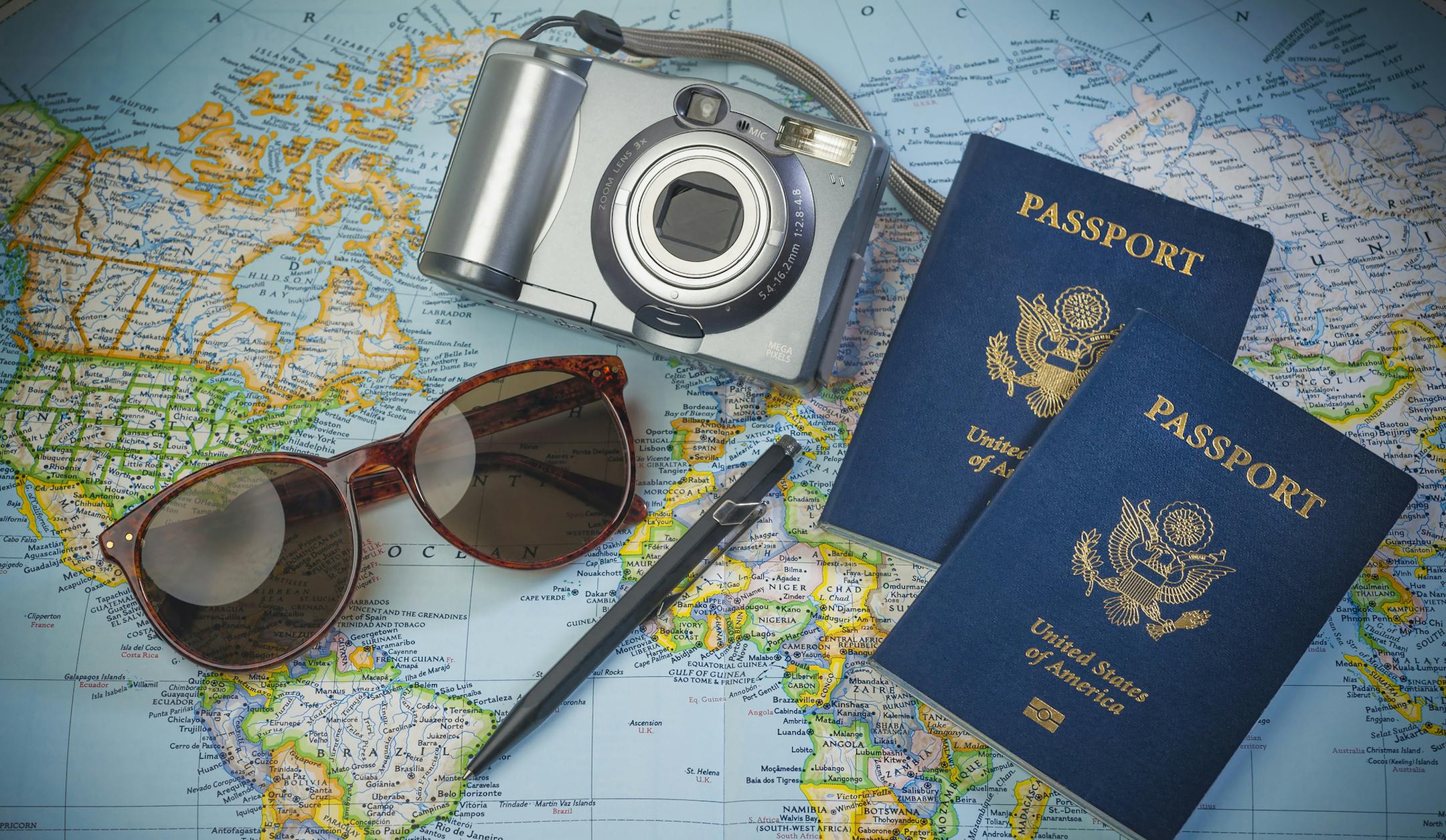 US Passports for travel,camera and glasses on a map of the world. iStockphoto.com