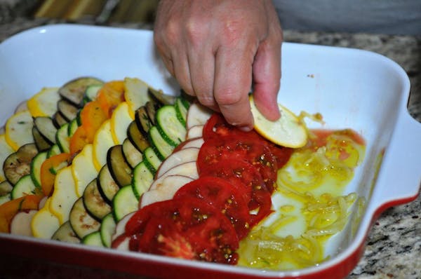 To prepare vegetable tian, arrange vegetable slices in overlapping rows over an onion mixture.