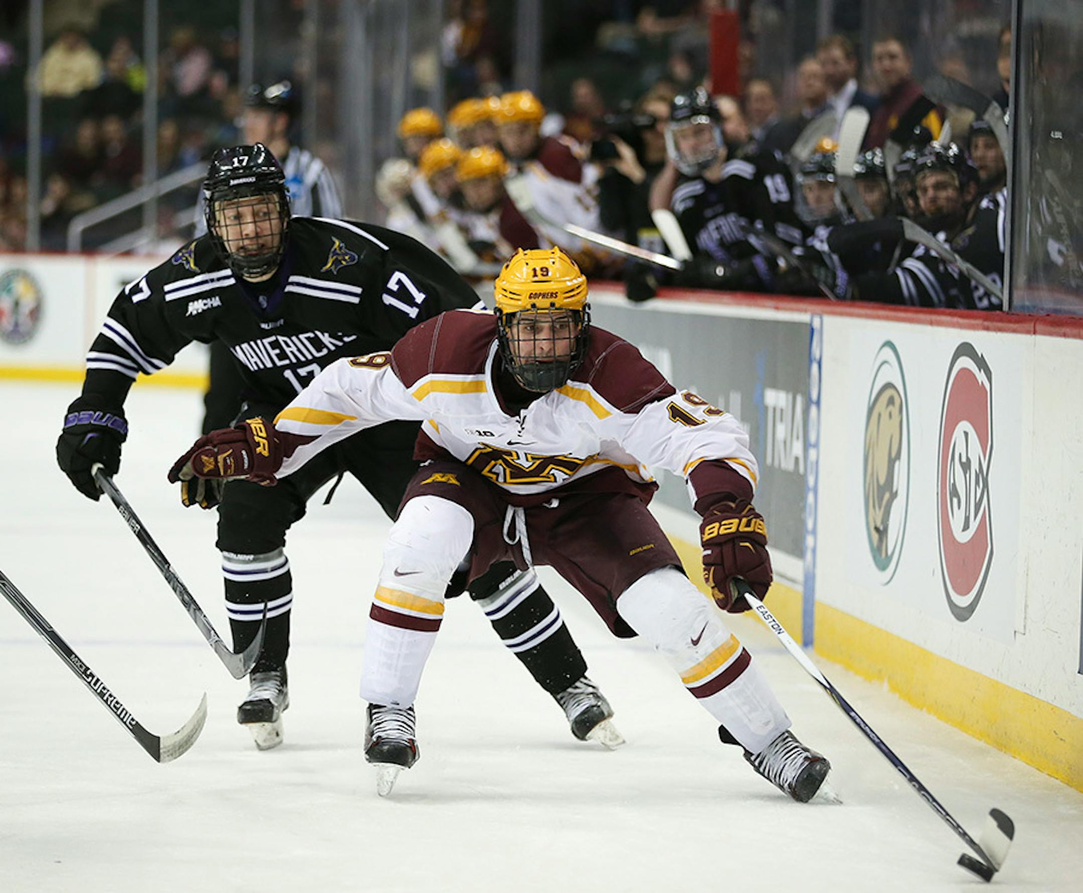 While on the power play, Gophers forward Vinni Lettieri (19) tried to control the puck after crossing the blue line trailed by Mavericks forward Michael Huntebrinker (17) in the third period Sunday afternoon.