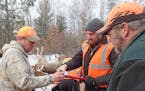 Brian Beck of Princeton, left, goes over paperwork with DNR biologist Andy Tri (holding clipboard) while checking in two deer at the CWD sampling stat
