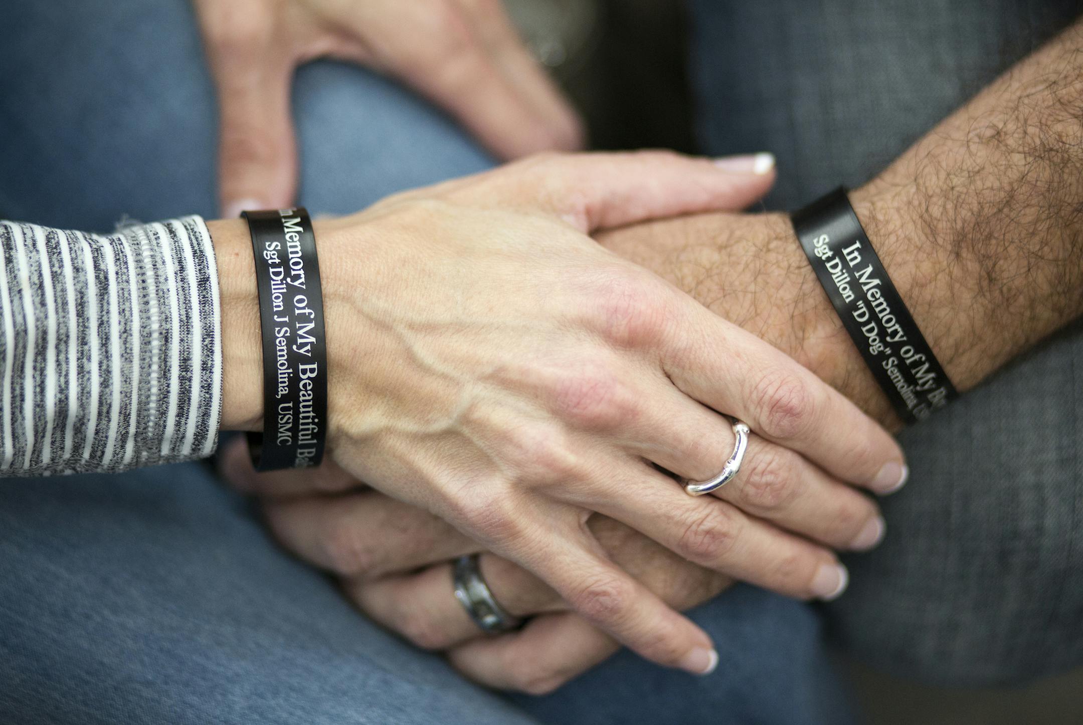Mike and Lisa De La Cruz hold hands while wearing bracelets as a tribute to her son and his stepson Dillon Semolina at their home in Bloomington on Wednesday, February 17, 2016. ] (Leila Navidi/Star Tribune) leila.navidi@startribune.com BACKGROUND INFORMATION: Sgt. Dillon Semolina, 24, of Chaska, Minn. died in a Hawaii helicopter crash on Jan. 14. Semolina was a crew chief with the Marine Heavy Helicopter Squadron.