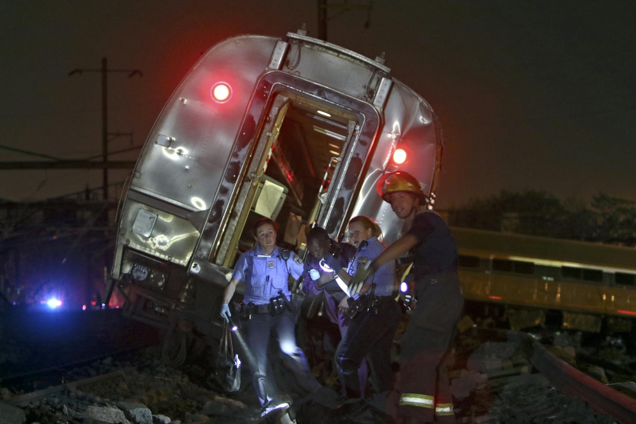 Emergency personnel work the scene of a deadly train wreck, Tuesday, May 12, 2015, in Philadelphia. An Amtrak train headed to New York City derailed and crashed in Philadelphia.