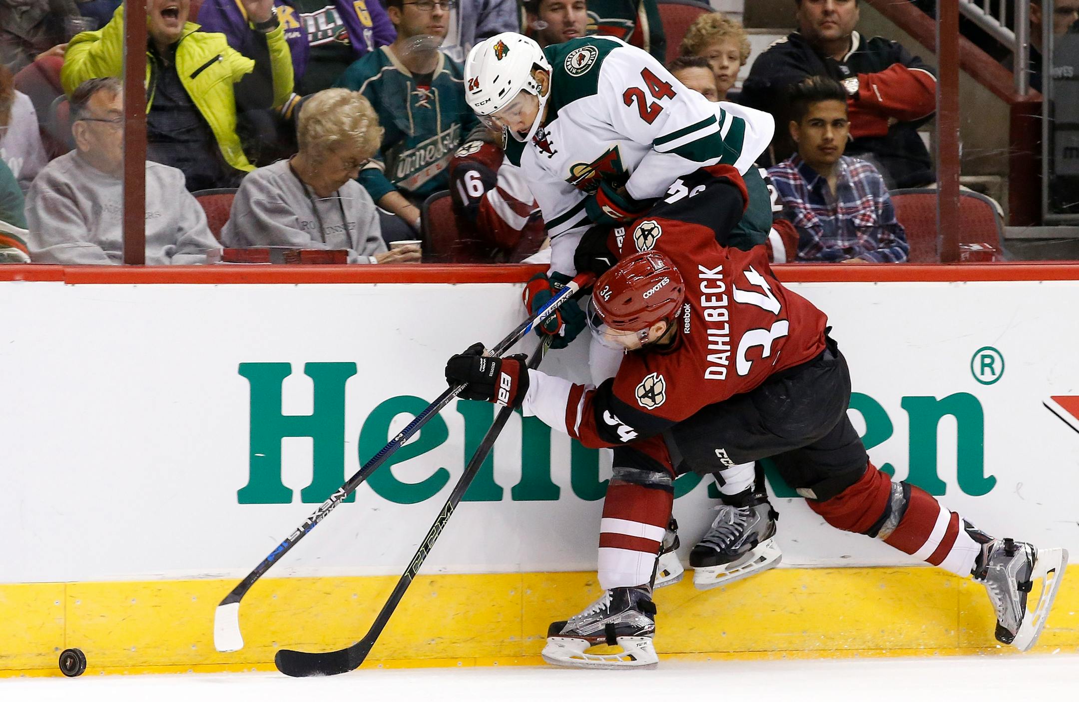 Arizona Coyotes' Klas Dahlbeck (34), of Sweden, shoves Minnesota Wild's Matt Dumba (24) into the boards during the first period of an NHL hockey game Friday, Dec. 11, 2015 in Glendale, Ariz. (AP Photo/Ross D. Franklin)