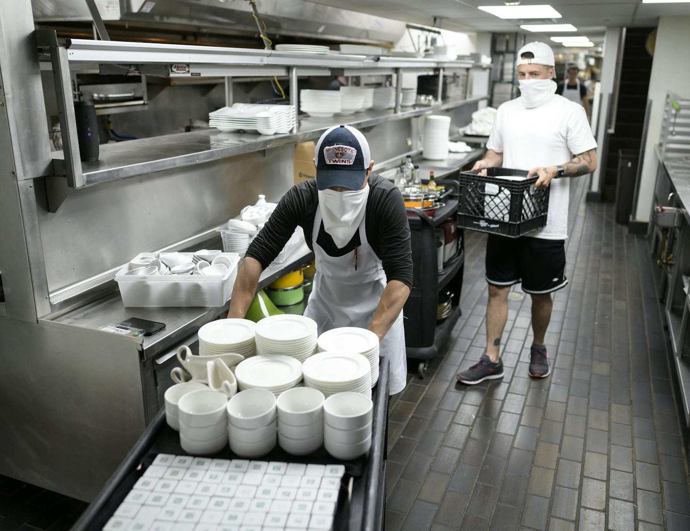 Andres Espinoza, an employee at Fhima's, and operations manager Eli Fhima, back right, worked on emptying the kitchen of all items before a deep cleaning and sanitizing. aaron.lavinsky@startribune.com Restaurants react to Gov. Walz's reopening order whatever it is. We photograph Fhima's as workers prepare for possible reopening on Wednesday, May 20, 2020 in Minneapolis, Minn.