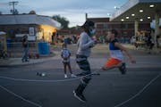 Marcia Howard jumped double dutch jump rope with Silas Yechout, 10, during a community dinner at the George Floyd memorial at 38th and Chicago in Minn