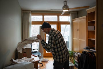 Dominic Papatola unpacks boxes in the office of his new home on Grand Avenue in St. Paul on Jan. 12. Papatola sold the house where he and his wife rai