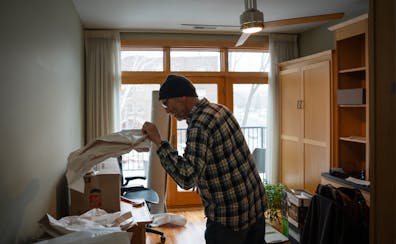 Dominic Papatola unpacks boxes in the office of his new home on Grand Avenue in St. Paul on Jan. 12. Papatola sold the house where he and his wife rai