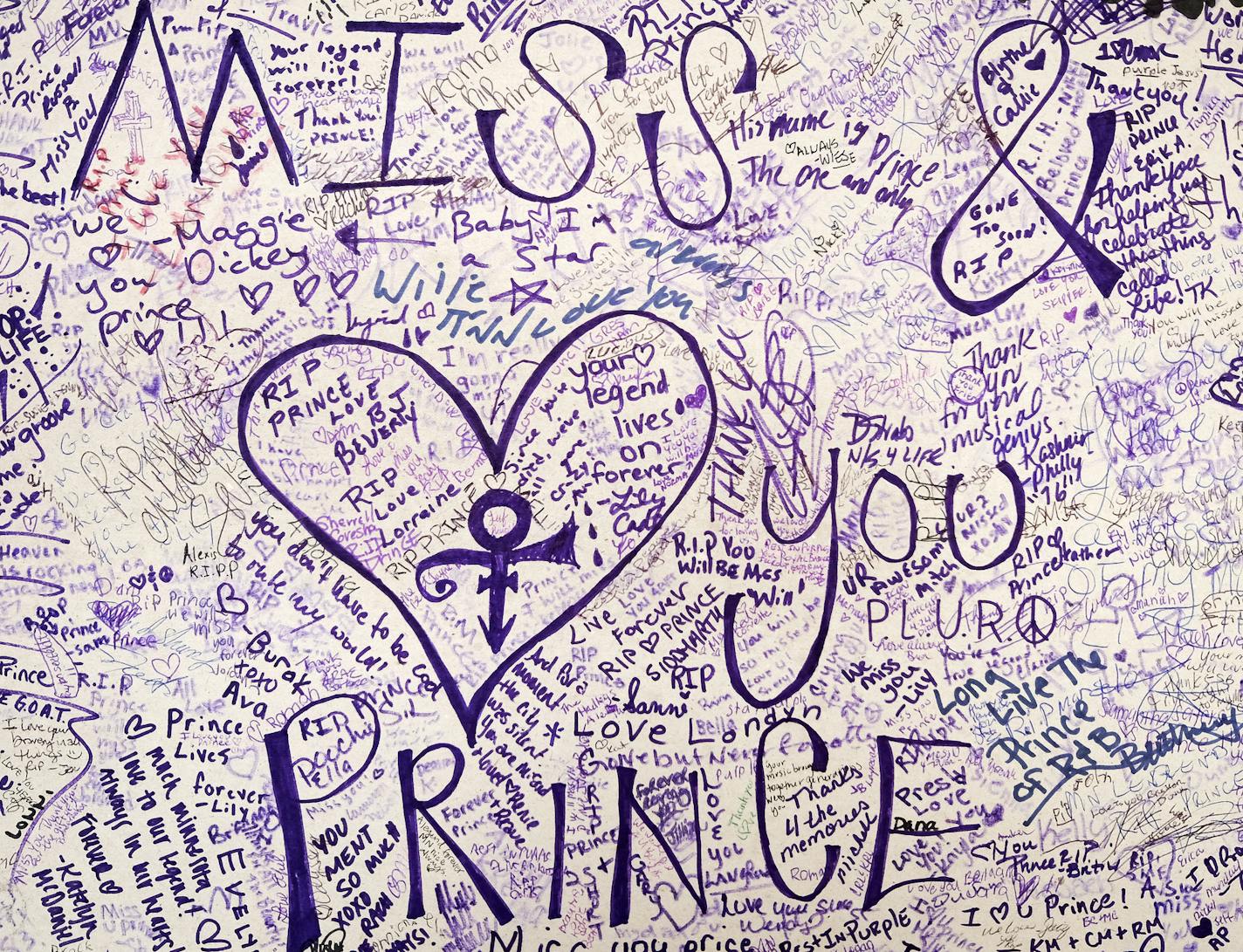 Every inch of a large poster is filled with notes of mourning and tribute on the wall outside First Avenue in Minneapolis.