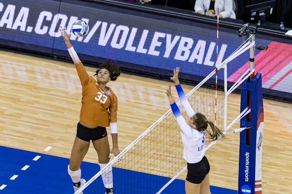 Texas' Logan Eggleston (33) hits the ball against Kentucky's Madison Lilley (3) in the first set during the finals in the NCAA women's volleyball cham