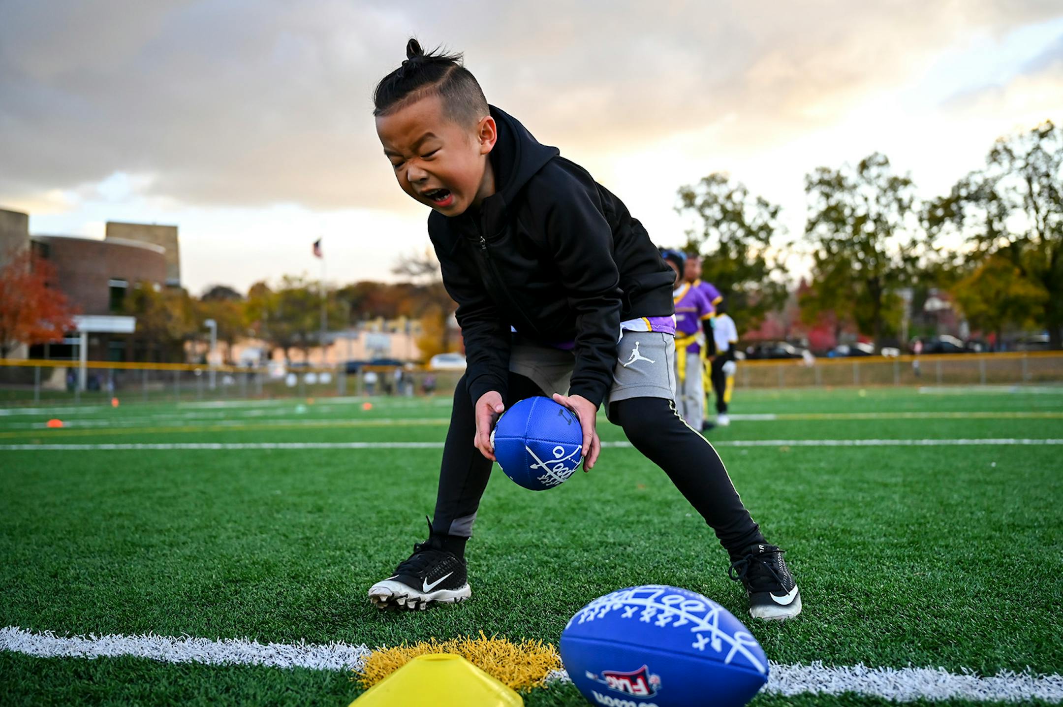 Chinyu Jordan Her, 6, hiked the ball during a U8 flag football practice Wednesday night.