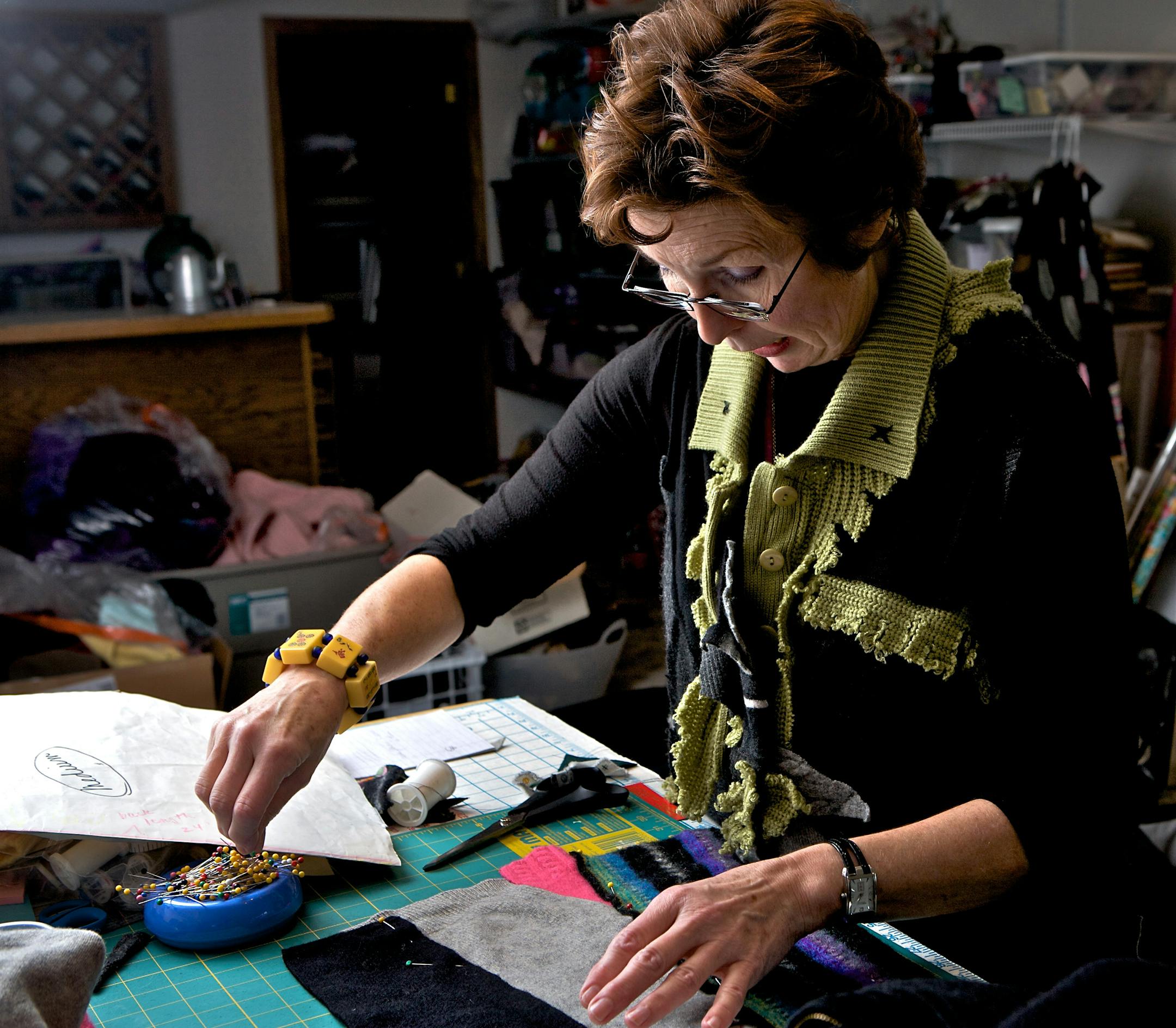 Marsha Theis works at home on one of the sweaters she makes from sweaters she buys at second-hand stores.