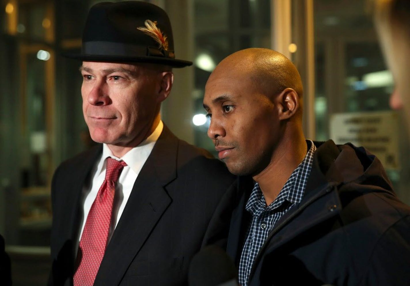 FILE - In this March 21, 2018, file photo, former Minneapolis Police Officer Mohamed Noor leaves the Hennepin County Public Safety Facility with his attorney, Thomas Plunkett, left, after posting bail in Minneapolis. Noor is charged with murder and manslaughter in the July death of Justine Ruszczyk Damond, who had called 911 to report a possible sexual assault behind her home. Police in Minneapolis announced Wednesday, April 4, 2018, new steps to make sure officers use body cameras in the wake o