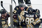Boston Bruins' David Pastrnak celebrates his Game 7 overtime goal with Morgan Geekie (39), Charlie McAvoy (73) and Brandon Carlo (25).