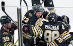 Boston Bruins' David Pastrnak celebrates his Game 7 overtime goal with Morgan Geekie (39), Charlie McAvoy (73) and Brandon Carlo (25).